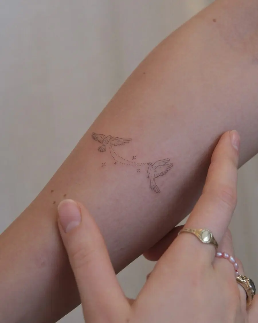 Elegant birds in subtle flight tattoo design