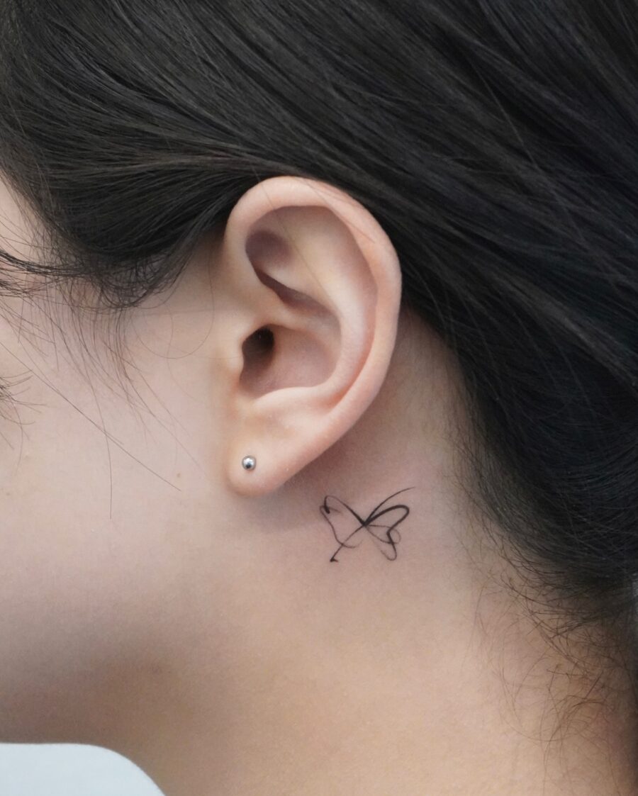 Delicate butterfly tattoo just behind the ear