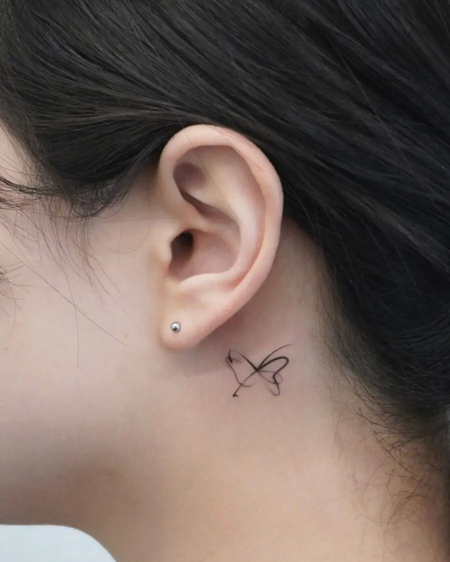Delicate butterfly tattoo just behind the ear
