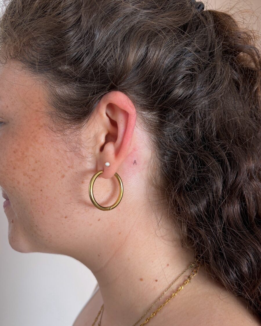 Subtle ear tattoo peeking from behind hair