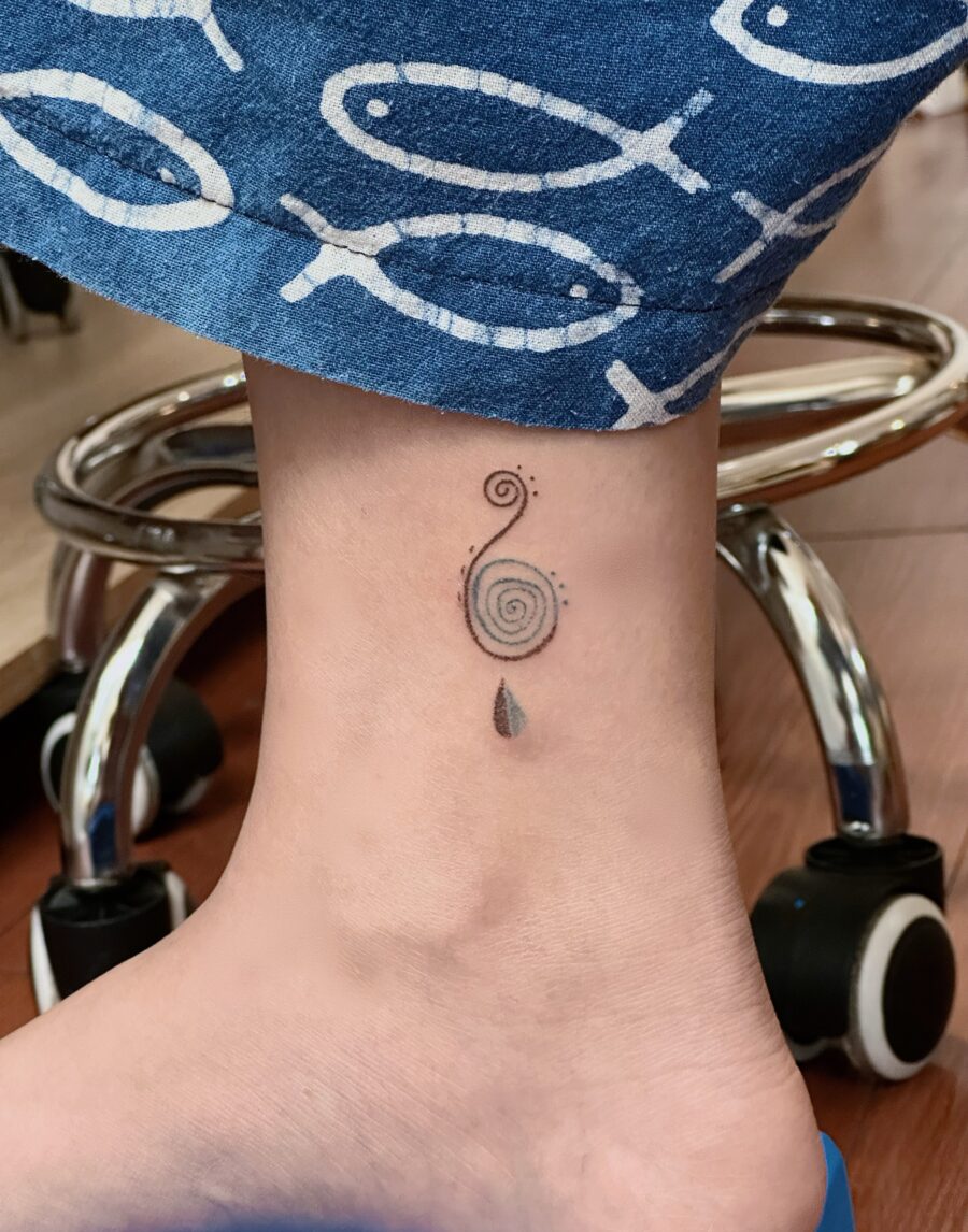 A captivating spiral tattoo on the ankle.