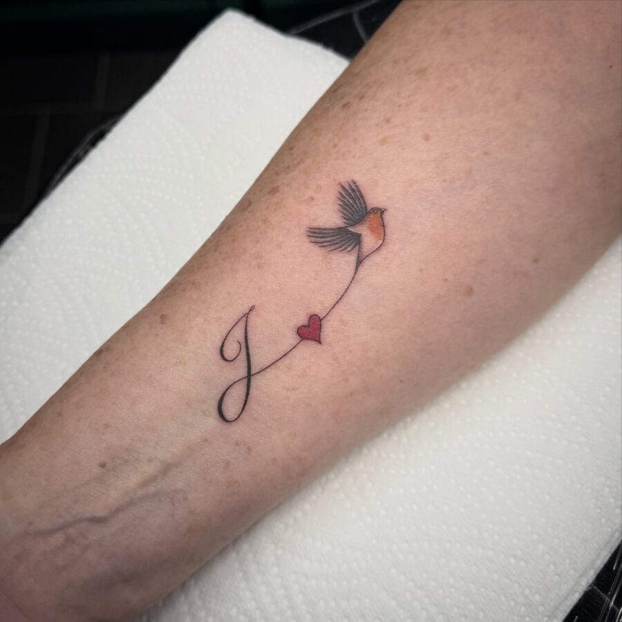 Symbolic bird and heart in memory tattoo