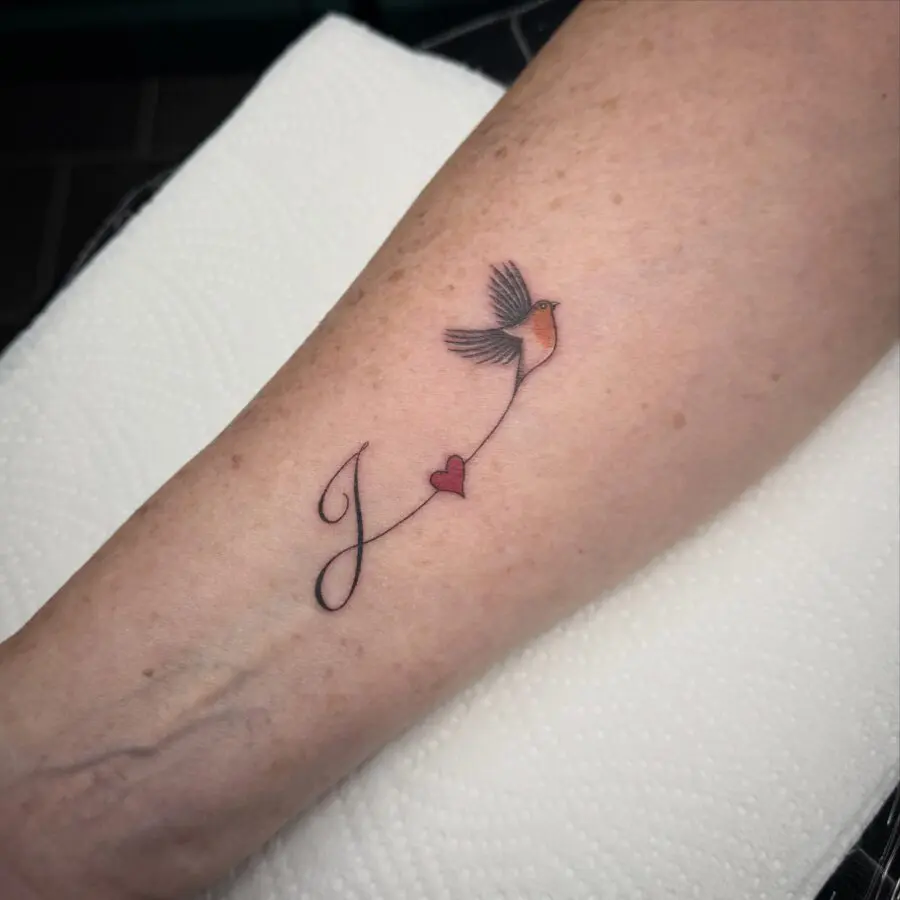 Symbolic bird and heart in memory tattoo
