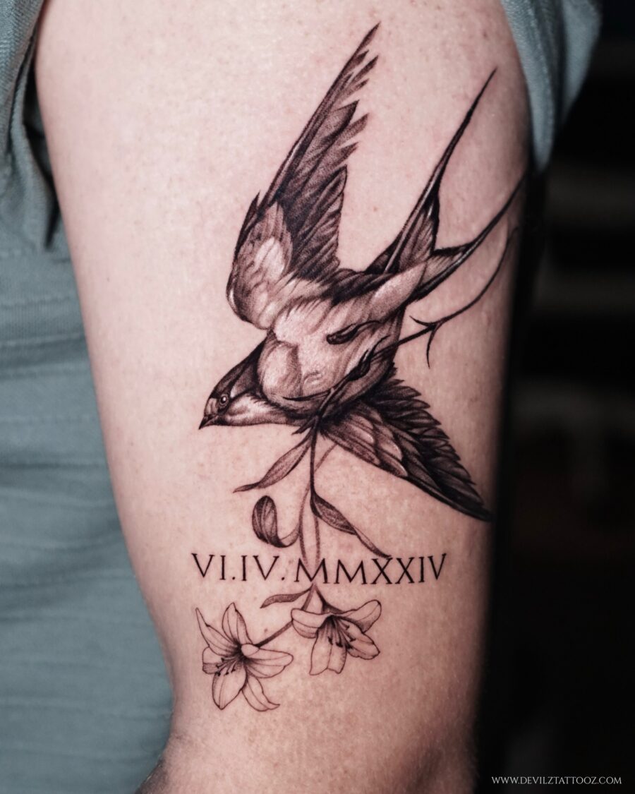 Elegant tribute tattoo featuring a swallow and flowers