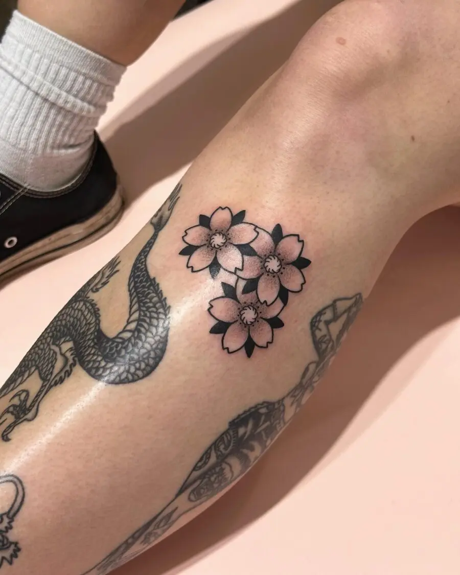 Elegant cherry blossoms tattoo on the calf