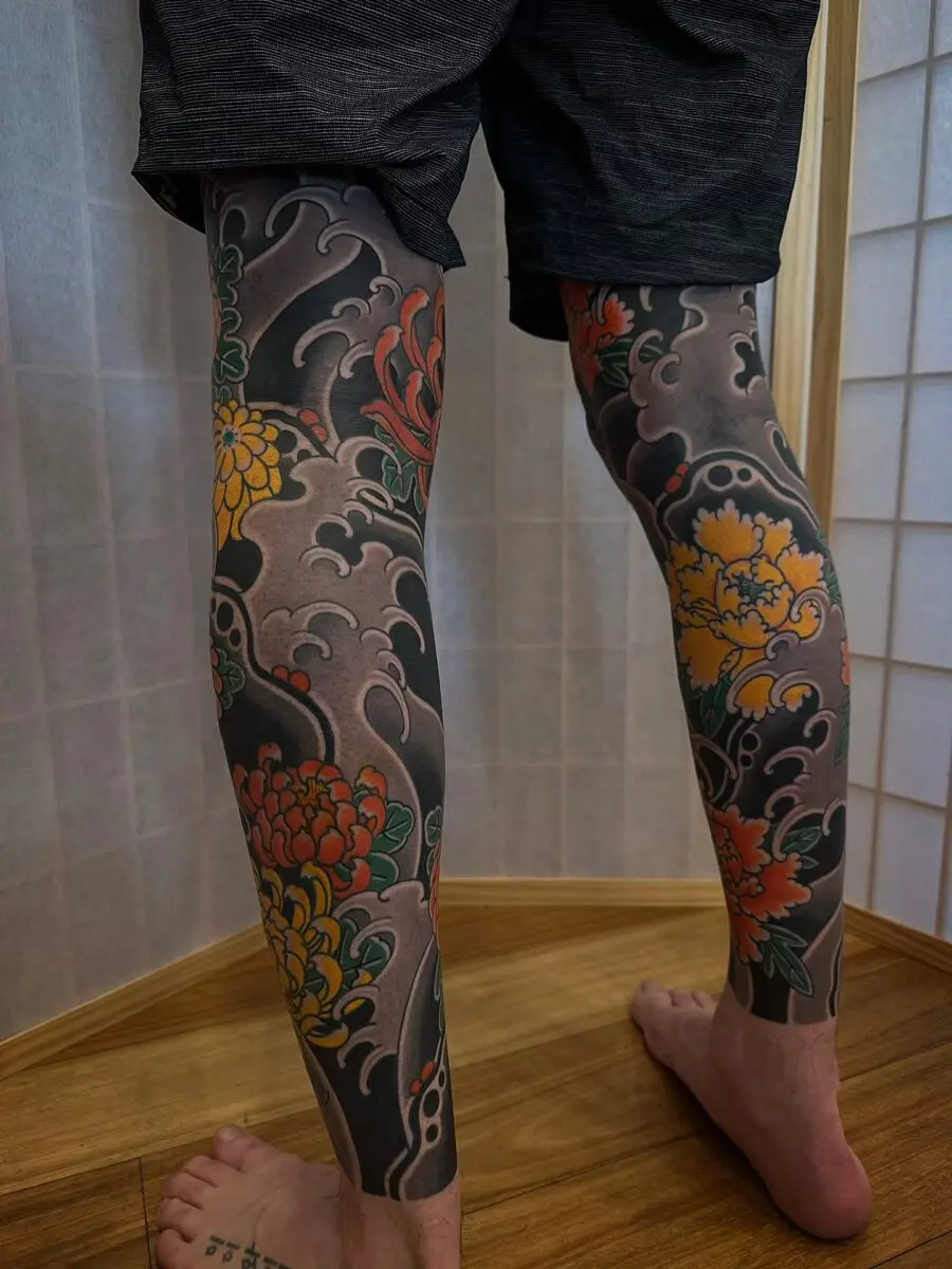 Vibrant floral Japanese tattoos adorn the legs