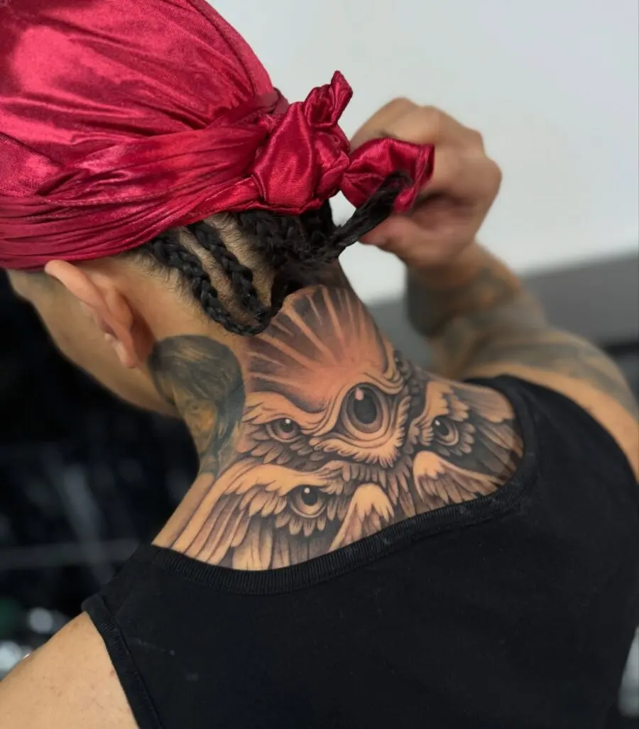 Intricate neck tattoo featuring eagle and feathers